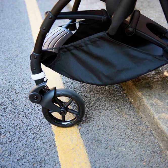 Close up of a Bugaboo stroller descending from a sidewalk kerb with ease.